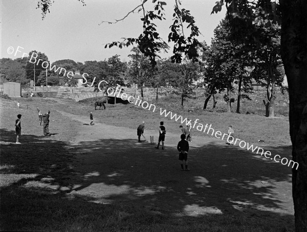 CHILDREN PLAYING CRICKET  BRIDGE IN BACKGROUND